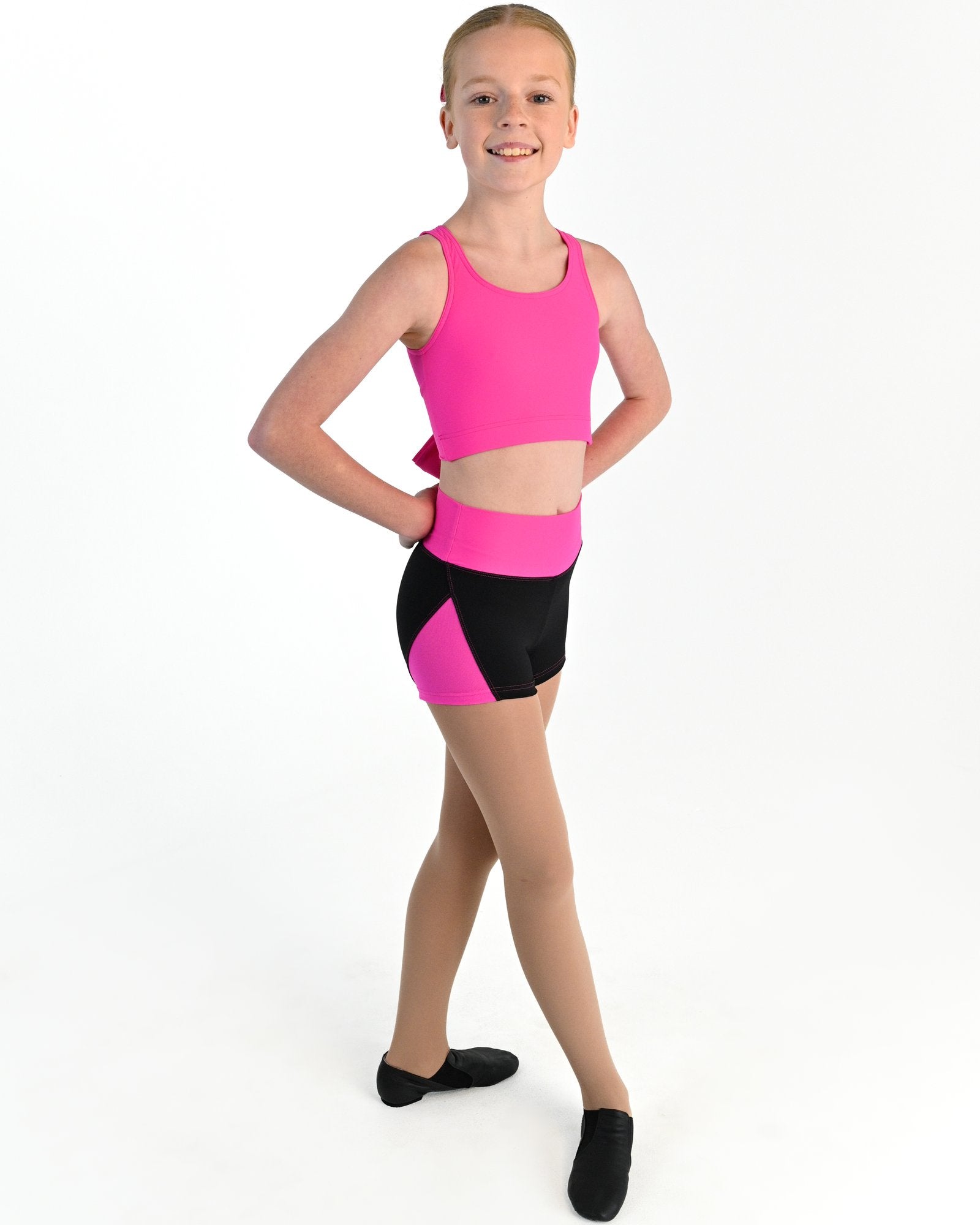 Young dancer wearing the Aura tie back dance crop top in Electric Pink