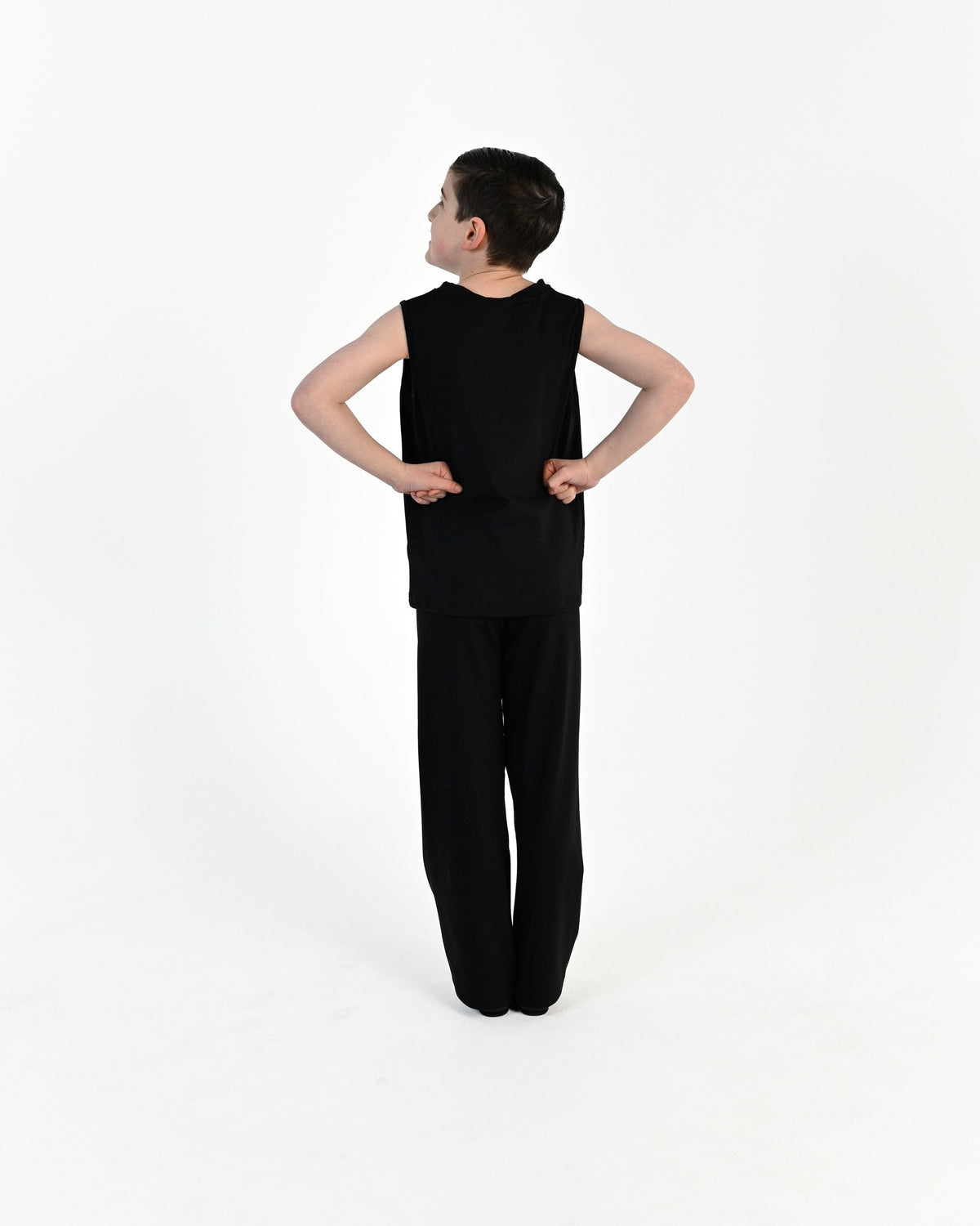 Young dancer wearing the Essential Boys Straight Leg Dance Pant in Black, alternate view