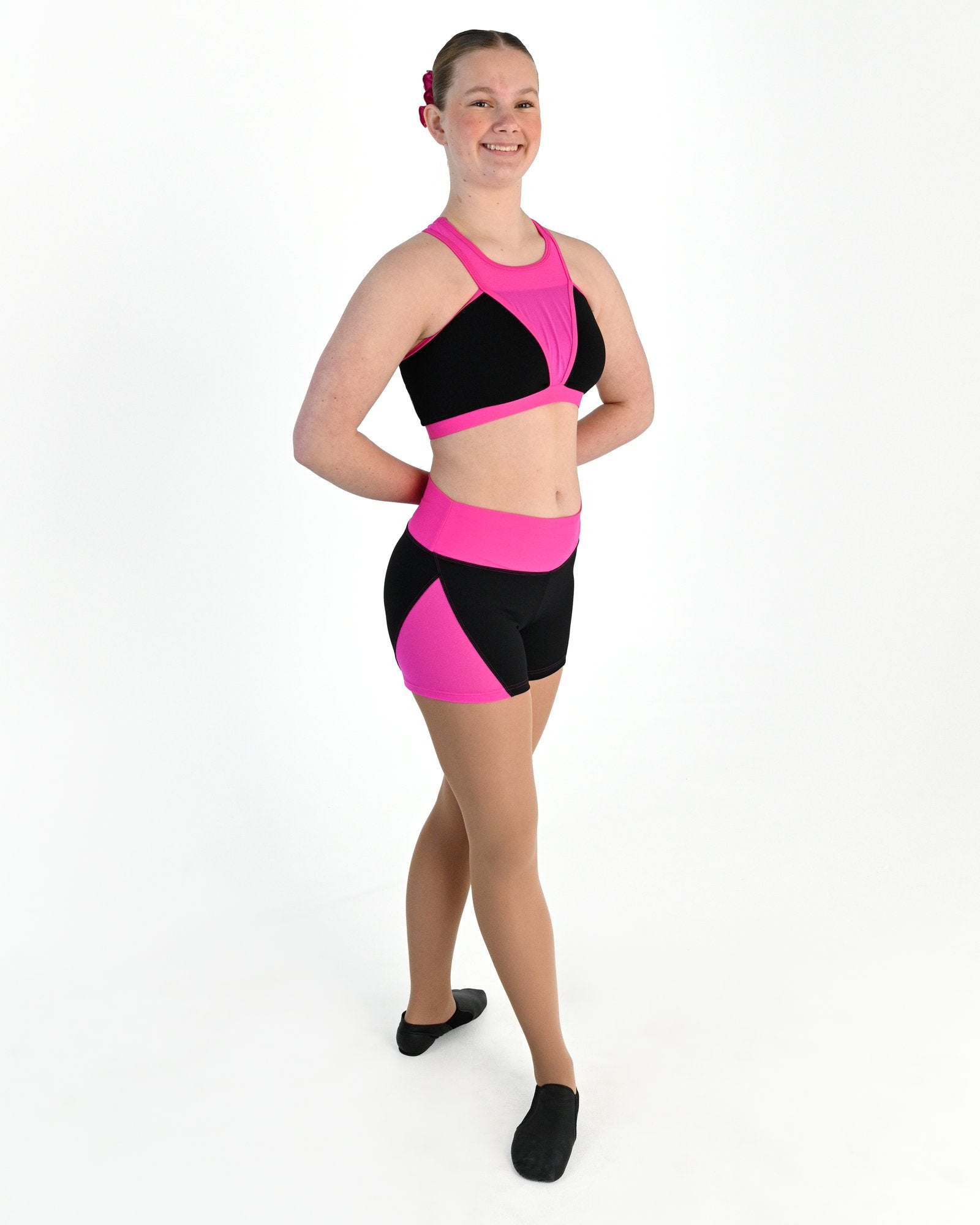Young dancer wearing the Electra mesh panel high waisted dance shorts in Electric Pink, alternate view