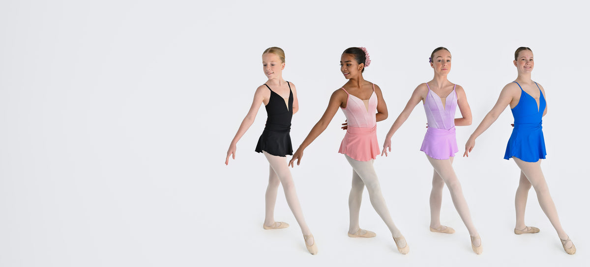 Four dancers in a line wearing the Prima ballet skirt in Black, Blush, Wisteria and Electric Blue
