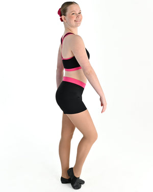 Young dancer wearing the Violet crossed back dance crop top with contrast binding in Hot Pink, alternate view