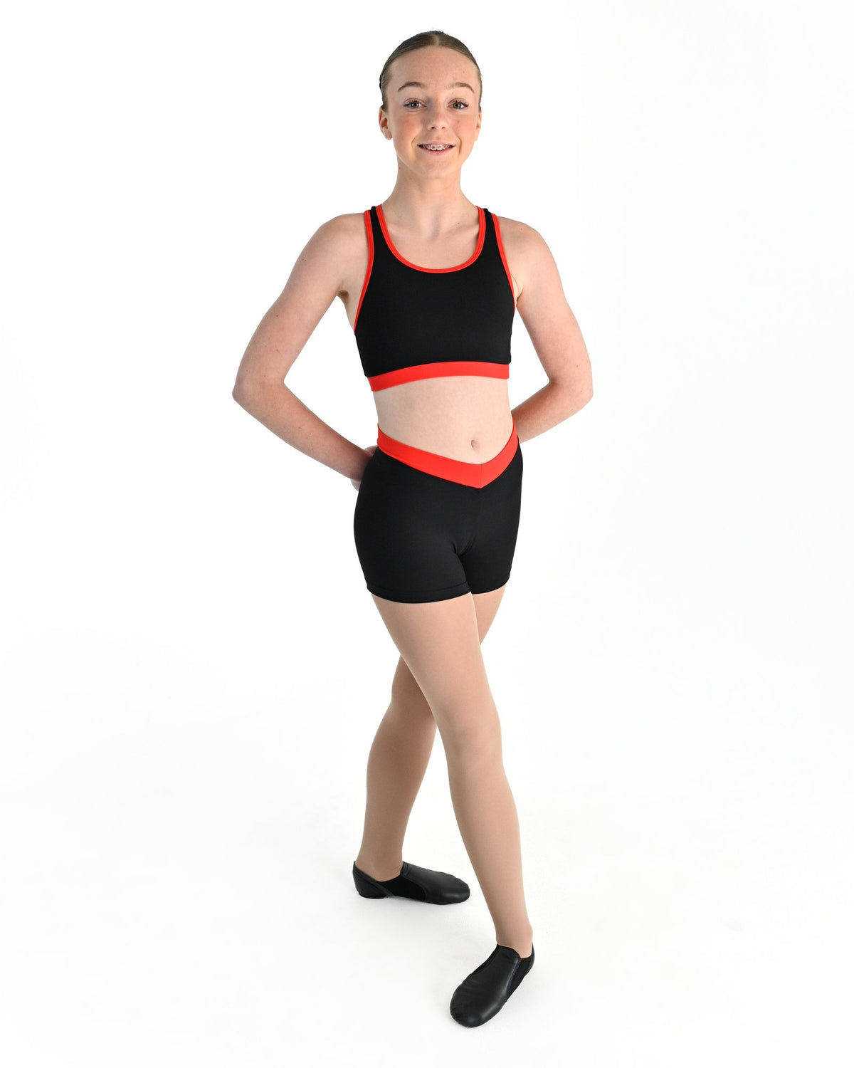 Young dancer wearing the Violet crossed back dance crop top with contrast binding in Red