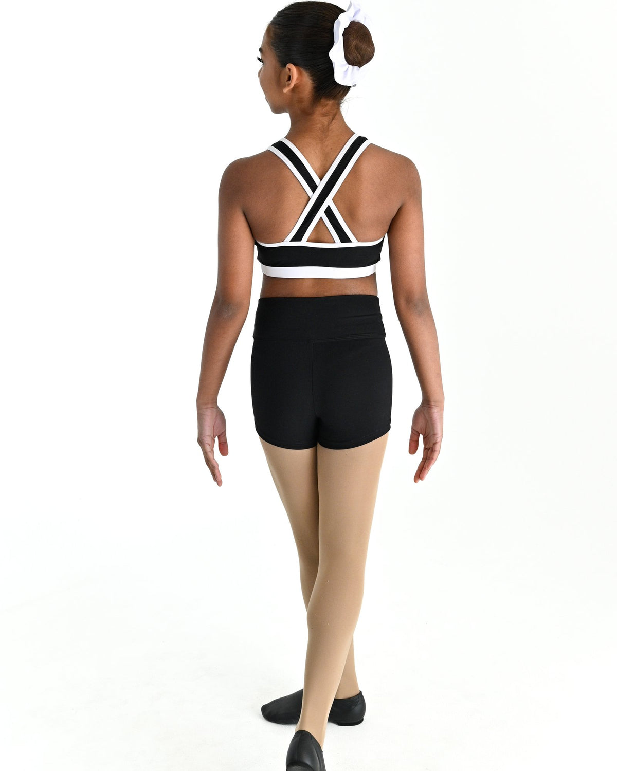 Young dancer wearing the Violet crossed back dance crop top with contrast binding in White, alternate view